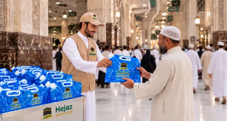 Hejaz Services volunteer handing a 5L Zamzam water bag to a pilgrim